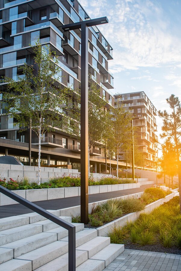 Vierkante lichtmast met tweevoudige uithouder in park &ndash; verlichting voor paden en pleinen